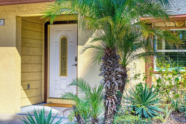 A house with a white door, a small porch, and a palm tree. - Luxury Family Home Near Downtown & Siesta Key Beach (Sarasota)