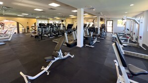 Un gimnasio con cintas de correr, elípticas y estaciones de pesas.