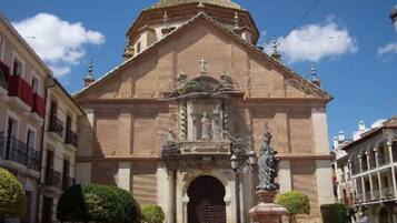 Un edifici històric amb una entrada destacada, una cúpula central i una estàtua al davant.