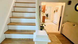 Eine Treppe mit Holzdielen und weißen Geländern, die zu einer Zwischenebene führt.