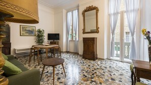 Una sala de estar con piso de baldosas, televisor, chimenea y un espejo grande.