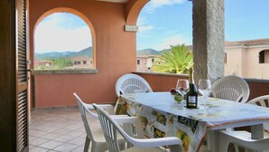 A terrace with a table set for two, featuring a bottle of wine and glasses. - La Ginestra Three-room apartment sleeps 6 (San Teodoro)
