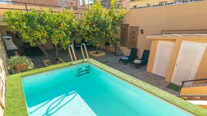 A swimming pool with a ladder, surrounded by grass, potted plants, and lounge chairs. - JUNIPER (INCA) - Cozy town house with above ground pool in the center of Mallorca. Free WI (Inca)