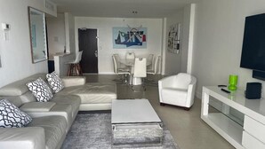 Un salon moderne avec un canapé, une table basse et un coin repas avec des chaises.
