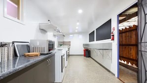 Eine moderne Küche mit Edelstahlgeräten, einer Marmorarbeitsplatte und Blick in einen Essbereich.