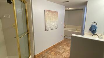 A bathroom with a shower, a sink, and a bathtub.