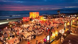 Un restaurant situé en bord de mer, avec une terrasse, une scène et une vue sur l’océan.