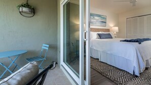 Un dormitorio con cama, una mesita de noche, una lámpara y un cuadro en la pared.