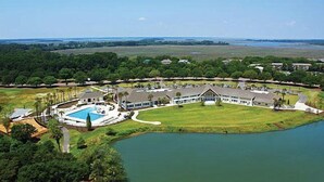 Un gran complejo turístico con un edificio central, una piscina y un lago.