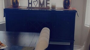 A modern living room with a dark wooden coffee table, a white sofa, and a decorative console table with the word "HOME" on it. - Relax near downtown Atlanta (Lithonia)