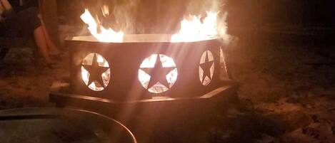 Ein Lagerfeuer mit einer Metallkonstruktion und sternförmigen Ausschnitten.