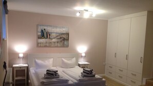 Una camera da letto con un letto grande, due comodini con lampade, un quadro appeso al muro e un armadio.