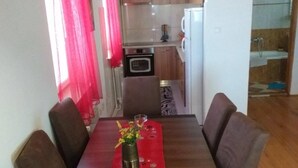 A dining area with a wooden table, six chairs, and a vase with flowers. - Remarkable 3-Bed House in Zabljak (Zabljak)