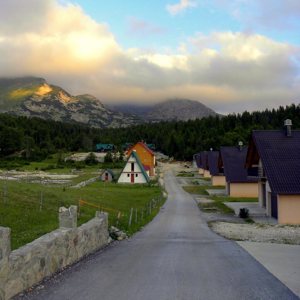 A row of traditional houses with a mountain backdrop.