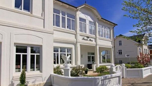 Un edificio blanco con un letrero que dice "The Hotel Bar".