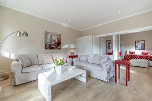 Ein modernes Wohnzimmer mit einer Couch, einem Couchtisch und einem roten Akzenttisch.