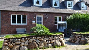 Une maison en briques avec un mur en pierre, une fenêtre et une porte.