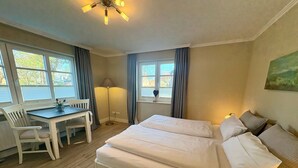 Ein Schlafzimmer mit einem Bett, einem Schreibtisch und einem Sessel.