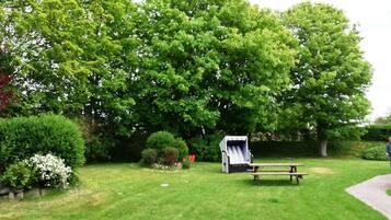 A picnic area with a table and benches, surrounded by lush greenery and trees.