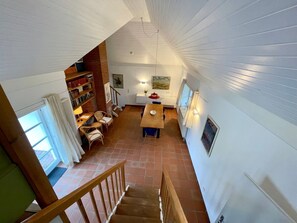Ein Loft-Zimmer mit Essbereich, einer Wendeltreppe und einer Bibliothek.