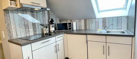 Una cocina con tragaluces, microondas y cafetera.