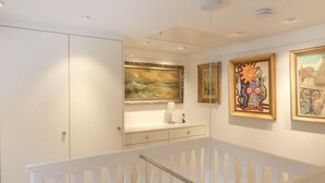 Een modern interieur met een witte trap, een witte muur en een plafond met inbouwverlichting.