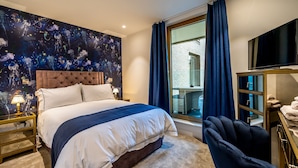 Une chambre d’hôtel avec un grand lit, une table de chevet, une télévision, une chaise et une vue sur l’extérieur.