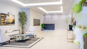 Un salon moderne avec un canapé, des fauteuils, une table basse et une cheminée.