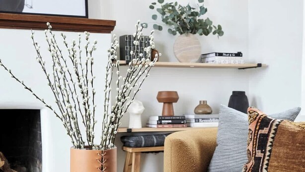 A cozy living room with a round coffee table, a sofa, a fireplace, and a bookshelf.