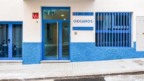 A building with a blue door and windows, labeled "Okeanos" and "Ecosuites."