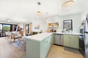 A modern kitchen with a central island, light green cabinets, and stainless steel appliances. - Walk to Kalapaki Beach, 3 lanais, full AC (Lihue)