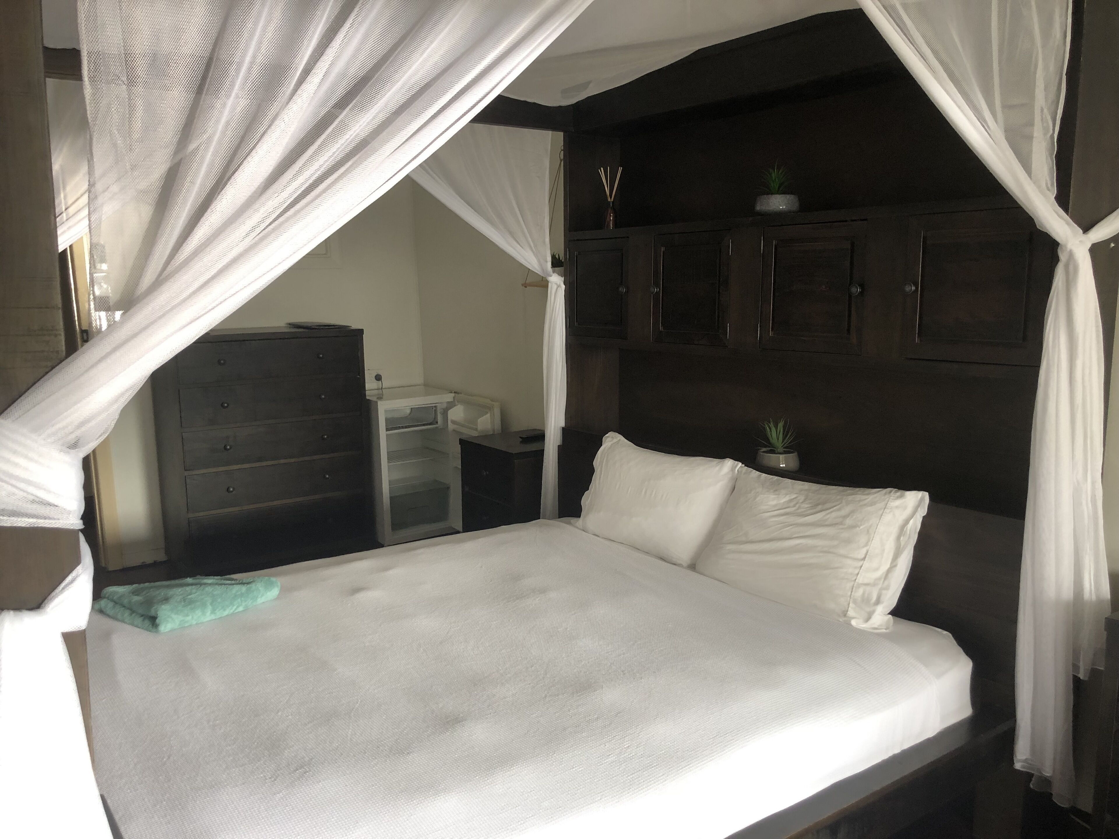 Clean tidy hotel room with a shared kitchen and shower area