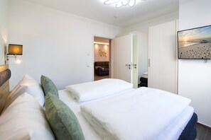 A hotel room with a bed, a TV, a lamp, and a painting on the wall. - Domizil Meerzeit, App. 2 (Heringsdorf)