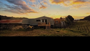 Un paysage rural avec une maison, une clôture en bois et un champ.