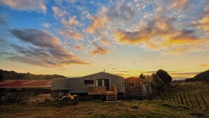 Ländliche Landschaft mit einem Haus, einem Holzzaun und einem Feld.
