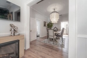Un intérieur moderne agrémenté d’une cheminée, d’un coin repas et d’un lustre.