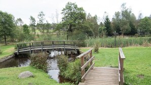 Een houten brug over een beekje in een park.