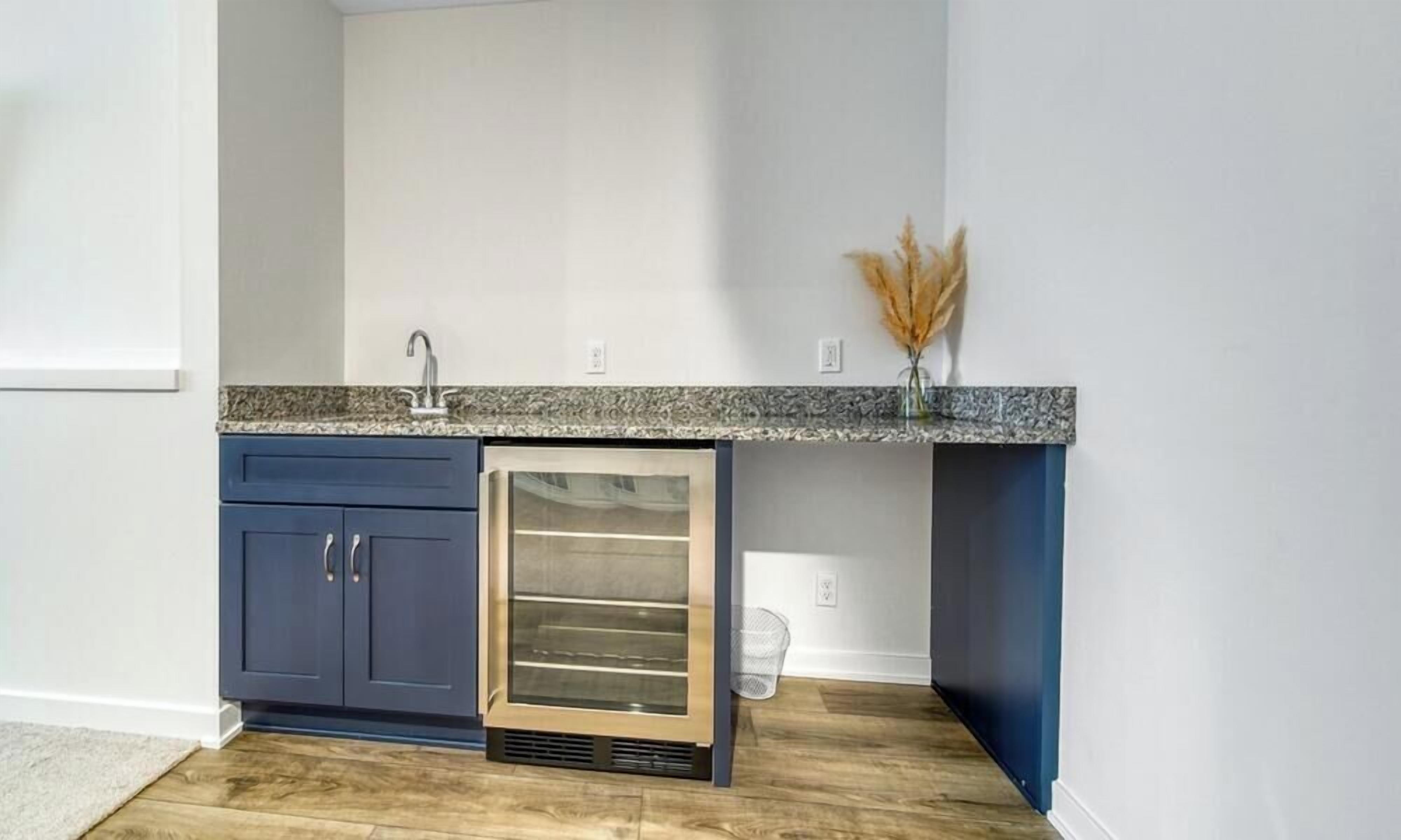 A kitchen with a built-in refrigerator, a granite countertop, and a blue cabinet.