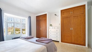 Une chambre à coucher avec un grand lit, une commode et deux armoires.