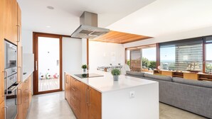 Een moderne keuken met een centraal eiland, houten kastjes en een ingebouwde kookplaat.