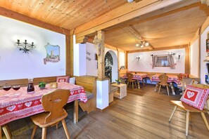 Ein gemütlicher Essbereich mit Holzkubituren, Tischen mit herzförmigem Tischläufer und rustikalem Interieur.