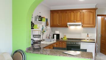 A kitchen with wooden cabinets, a granite countertop, and a stainless steel range hood.
