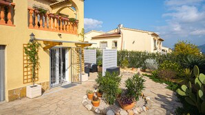 A Mediterranean-style building with a stone patio, potted plants, and outdoor furniture. - Apartment "La Mandarina" with Mountain View, Pool, Wi-Fi, A/C & Terrace (Palmeria)