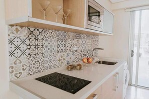 A modern kitchen with patterned backsplash, a built-in oven, and a sink.