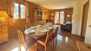 A cozy wooden cabin with a dining area, a living room, and a kitchen. - Spacious 3-Room Apartment in Praz-Sur-Arly, Sleeps 6, Central Location, Parking Included (Praz-sur-Arly)
