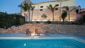 A stone building with a pool, two lounge chairs, and palm trees. - Charming house with shared pool - Don Carlo (Buseto Palizzolo)