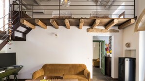 A modern kitchen with a wooden ceiling, a dining area with a brown sofa and a table with fruit, and a staircase with a hanging decoration. - Charming house with shared pool - Don Carlo (Buseto Palizzolo)