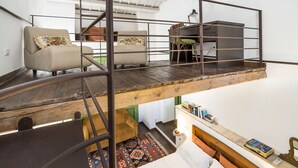 A loft-style bedroom with a wooden platform bed, a sofa, and a desk area. - Charming house with shared pool - Don Carlo (Buseto Palizzolo)
