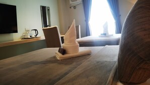 A hotel room with a bed, a chair, a TV, a window with curtains, and a small table with a kettle and cups. - Yes Hotel Pandi Bulacan (Pandi)