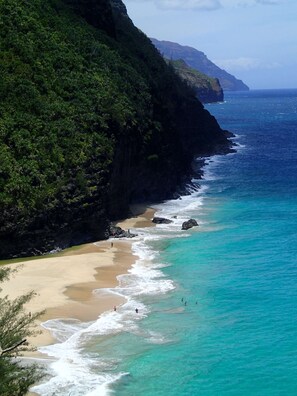 A coastal landscape with a sandy beach, clear turquoise waters, and lush green cliffs. - (P17D) Hale Blue Hawaii 1Br with Loft, Puamana, Pool, Wifi (Princeville)
